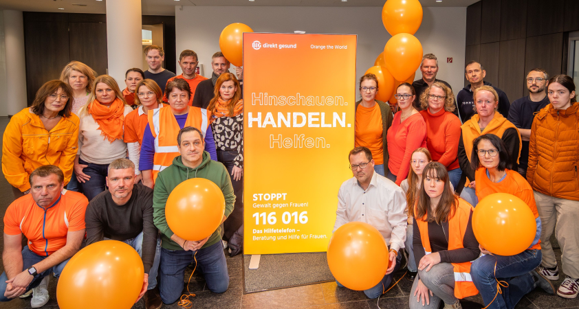 Gruppenfoto Mitarbeitende BIG direkt gesund in orange gekleidet