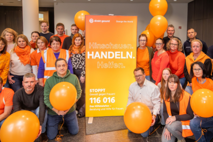 Gruppenfoto Mitarbeitende BIG direkt gesund in orange gekleidet